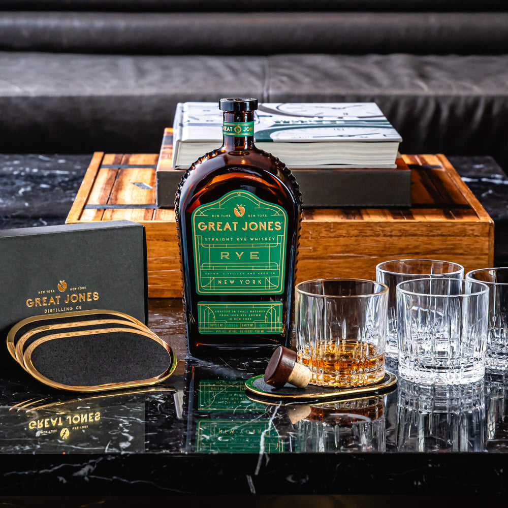 
                  
                    Great Jones Rye Whiskey with Crystal Rocks Glass (set of 4) and Brass Coasters (Set of 4)
                  
                